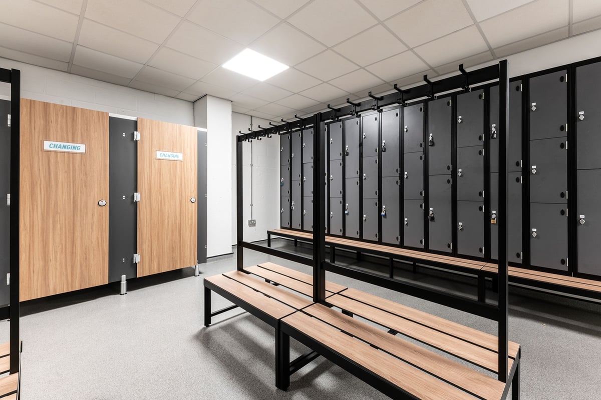 PureGym London Hammersmith Palais: Rows of lockers, benches, and partitions make up this changing room interior.