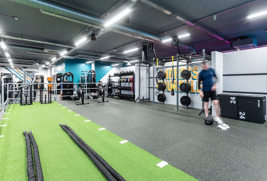 PureGym Walton-on-thames: Functional training area with weight racks, turf, resistance bands, and free weights visible.