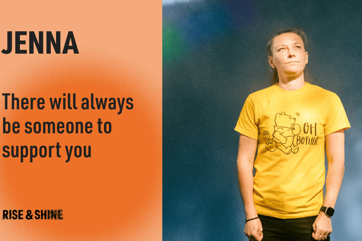 Woman in yellow Winnie the Pooh t-shirt standing against a dark background