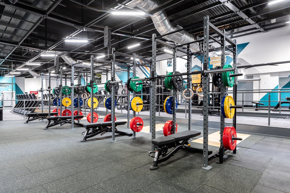 PureGym Southampton Bitterne: Racks with weight plates, benches, rubberised flooring in an industrial-style gym.