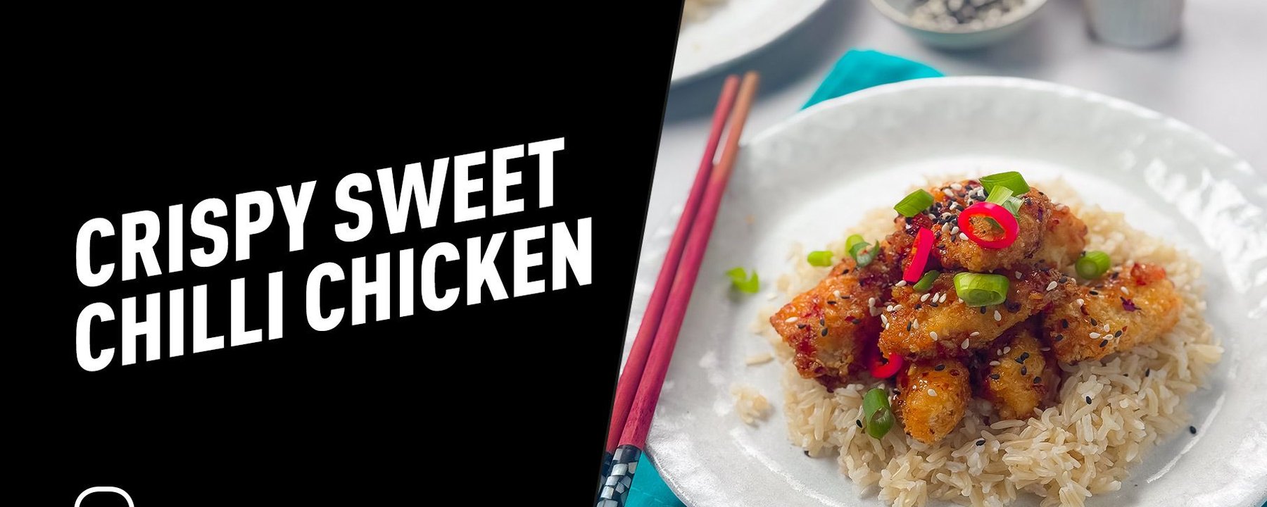 Crispy sweet chilli chicken on rice garnished with spring onions and red chillies.