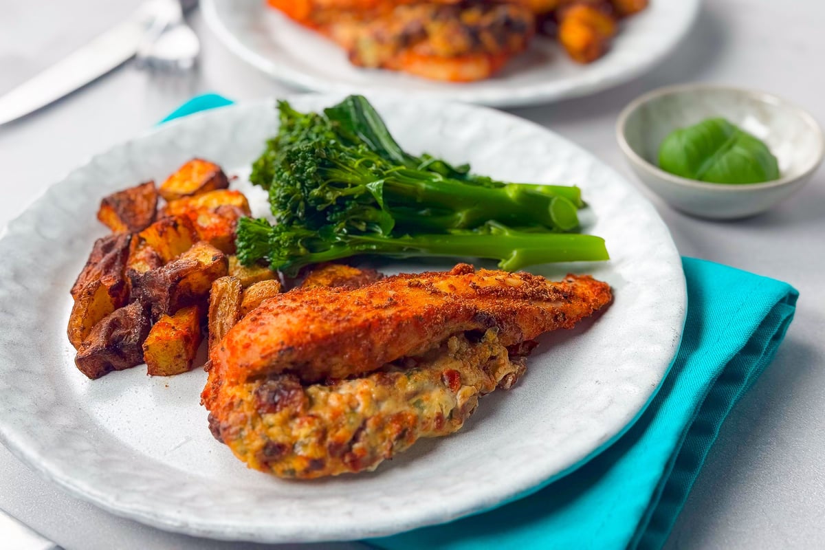 Grilled chicken breast with roasted vegetables and steamed broccoli on white plate