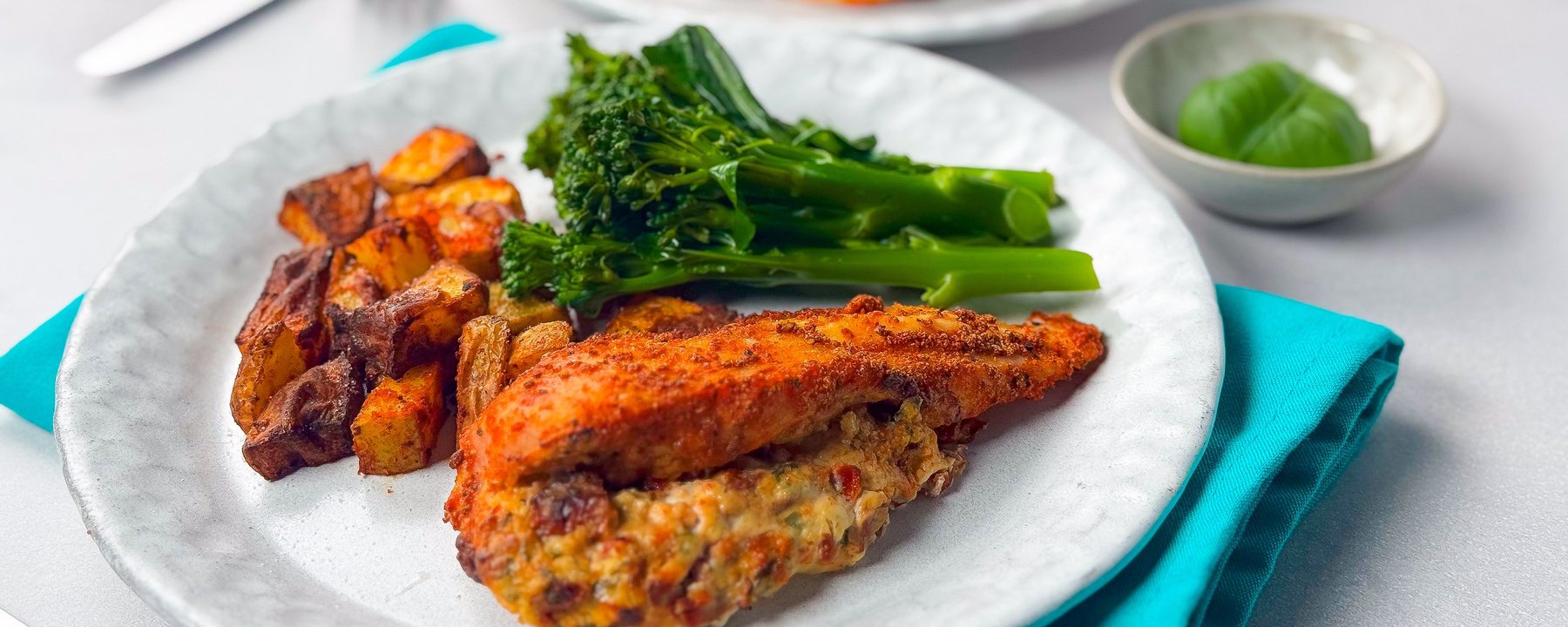 Grilled chicken breast with roasted vegetables and steamed broccoli on white plate