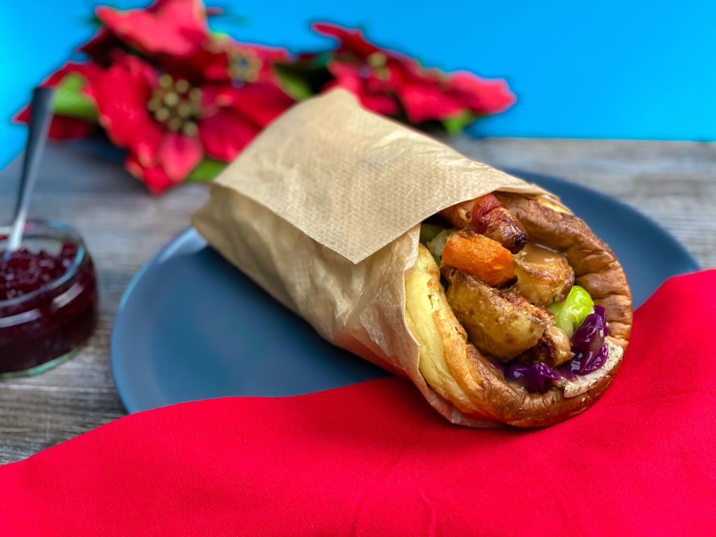 Yorkshire pudding wrap filled with roast vegetables on a blue plate with red cloth