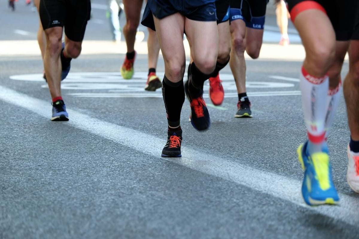 Group of runners in colourful trainers running on a road during a marathon race