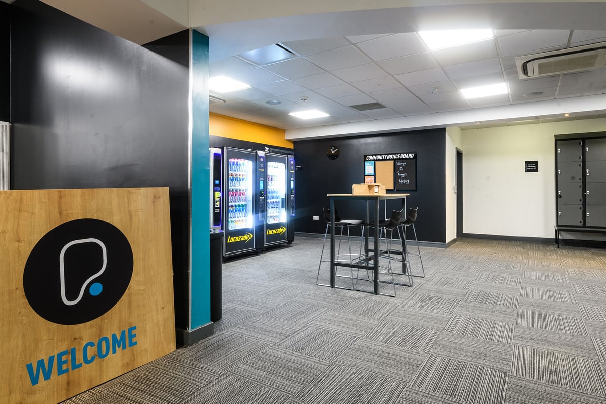 PureGym Aylesbury: Vending machines, seating area, and directional signage within a commercial space.