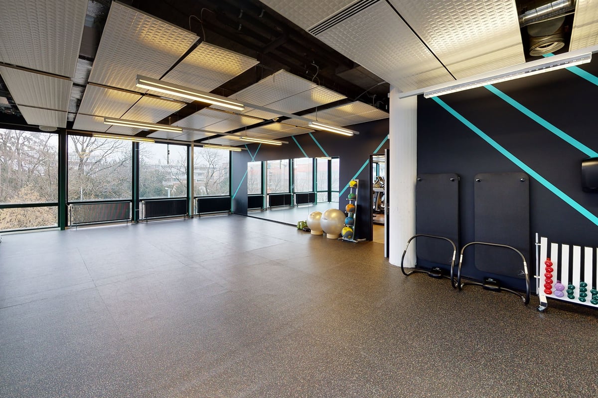 PureGym Biel Bienne: Studio avec équipement de musculation, sol caoutchouté, grandes fenêtres donnant sur le paysage.