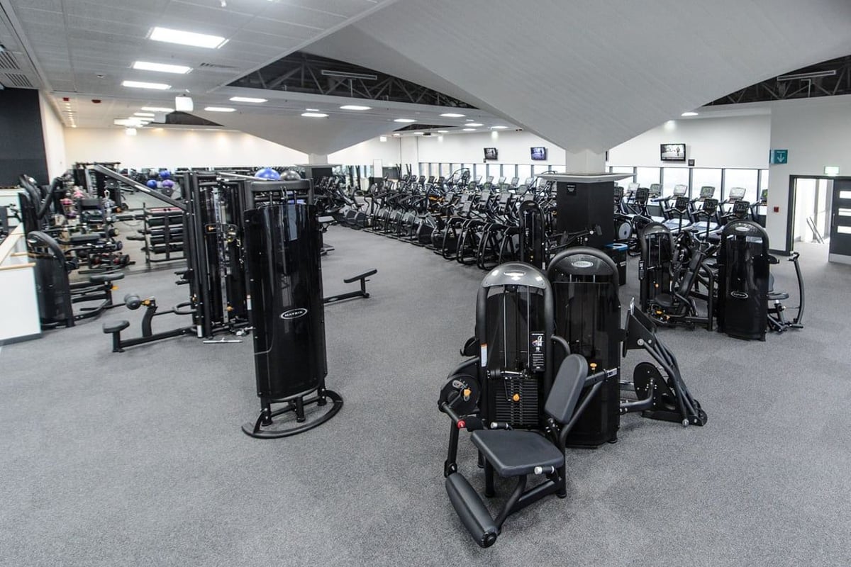 PureGym Bedford Heights: Strength training machines, free weights, benches and rubberized flooring in a gymnasium setting.