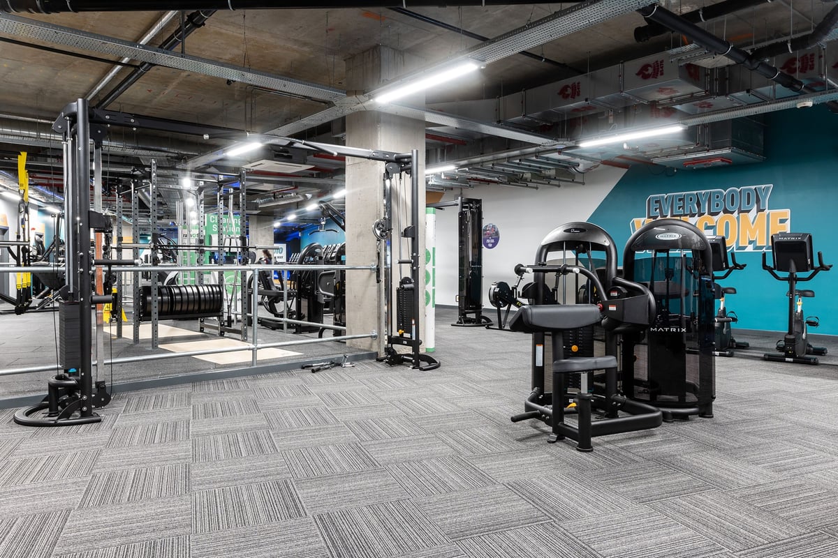PureGym London Hoxton: Gym interior with weight machines, free weights, rubberized flooring, and motivational wall mural.
