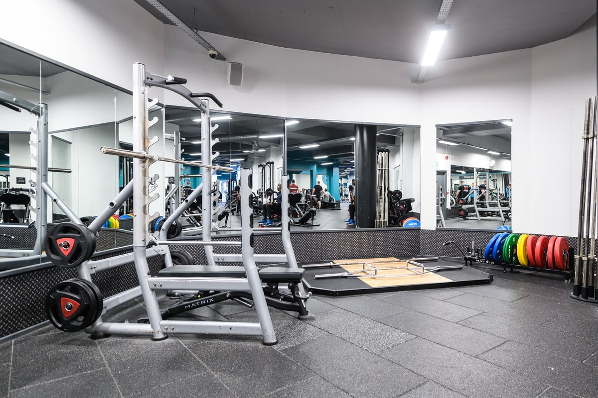 PureGym Bournemouth The Triangle: Gym with squat racks, weight plates, benches, mirrors, and rubberized flooring visible.