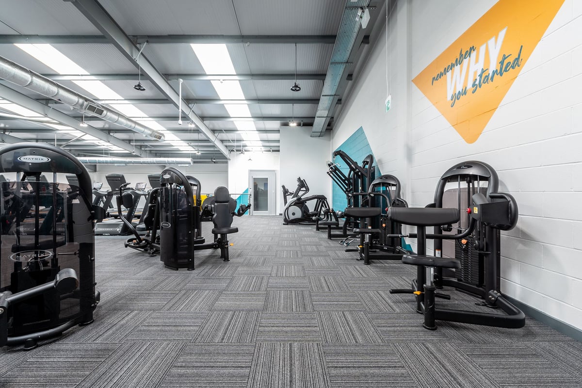 PureGym Coventry Warwickshire Shopping Park: Rows of strength training machines, benches and rubberized flooring.