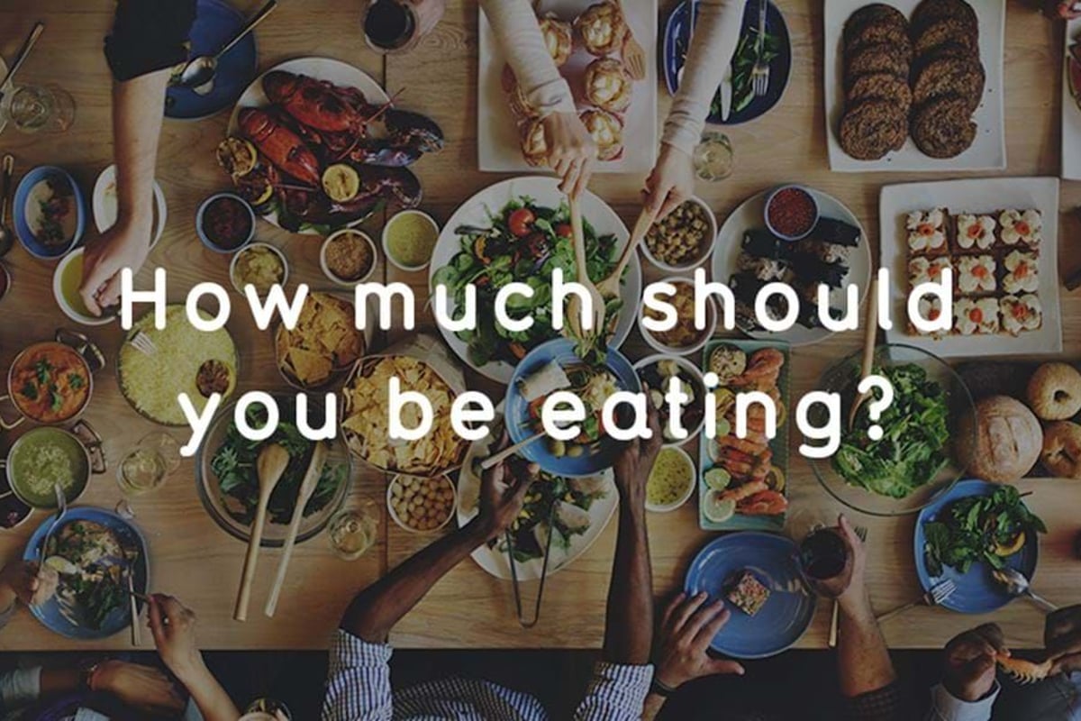People sharing a large meal with various dishes including salad, bread, and seafood on a w