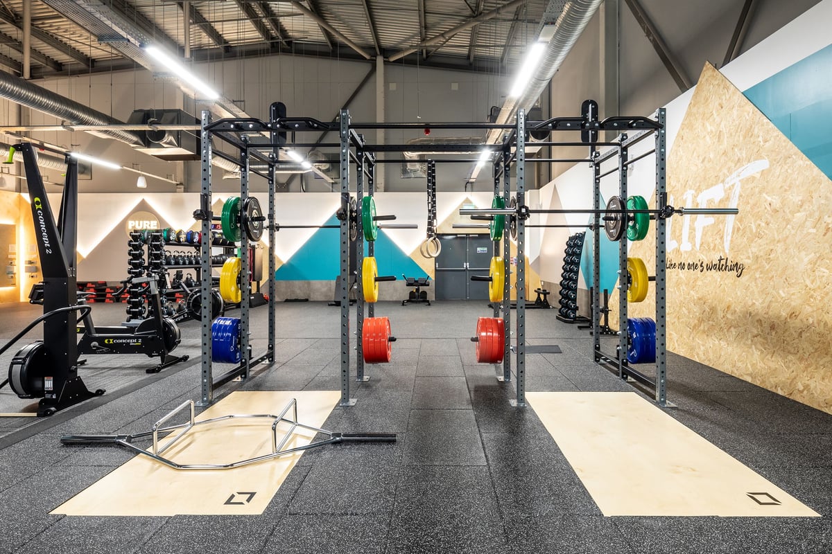 PureGym Wantage: Resistance machines, weight racks, rubberized floors in a fitness studio.