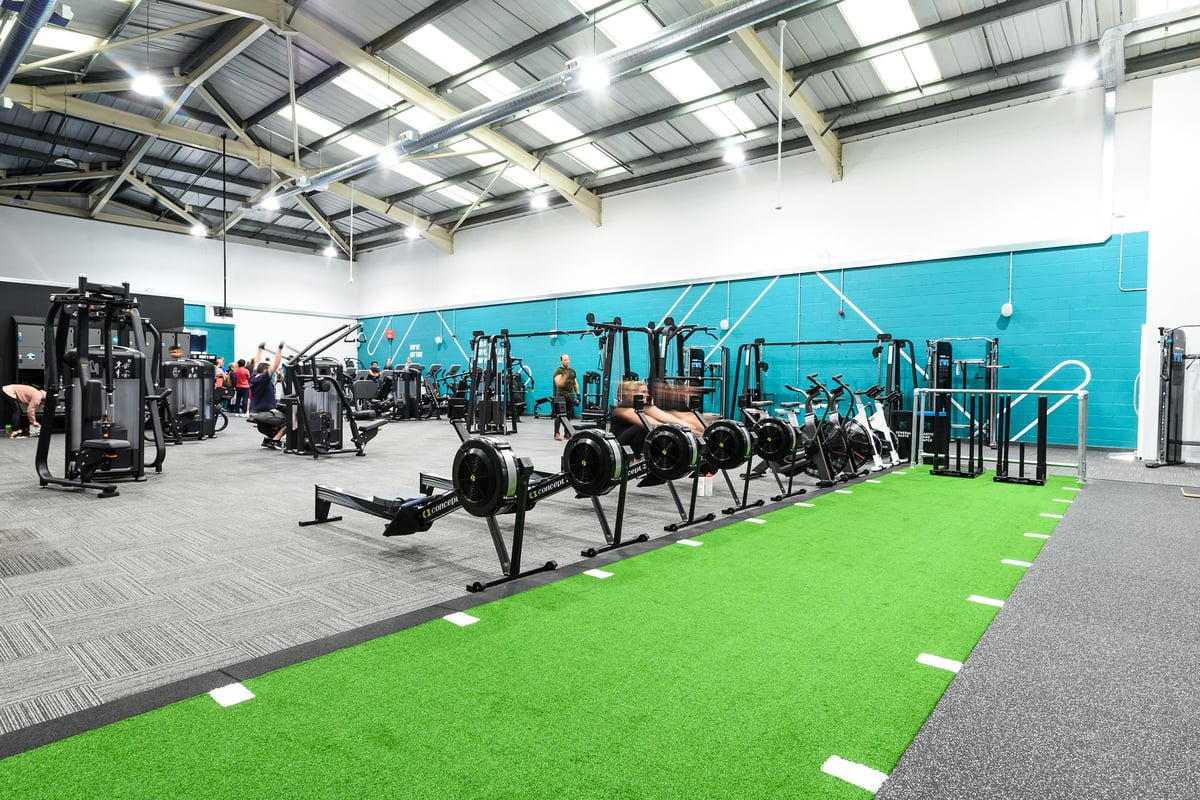 PureGym Burgess Hill: Resistance machines, free weights, functional training rig with green turf, and rubberized flooring.