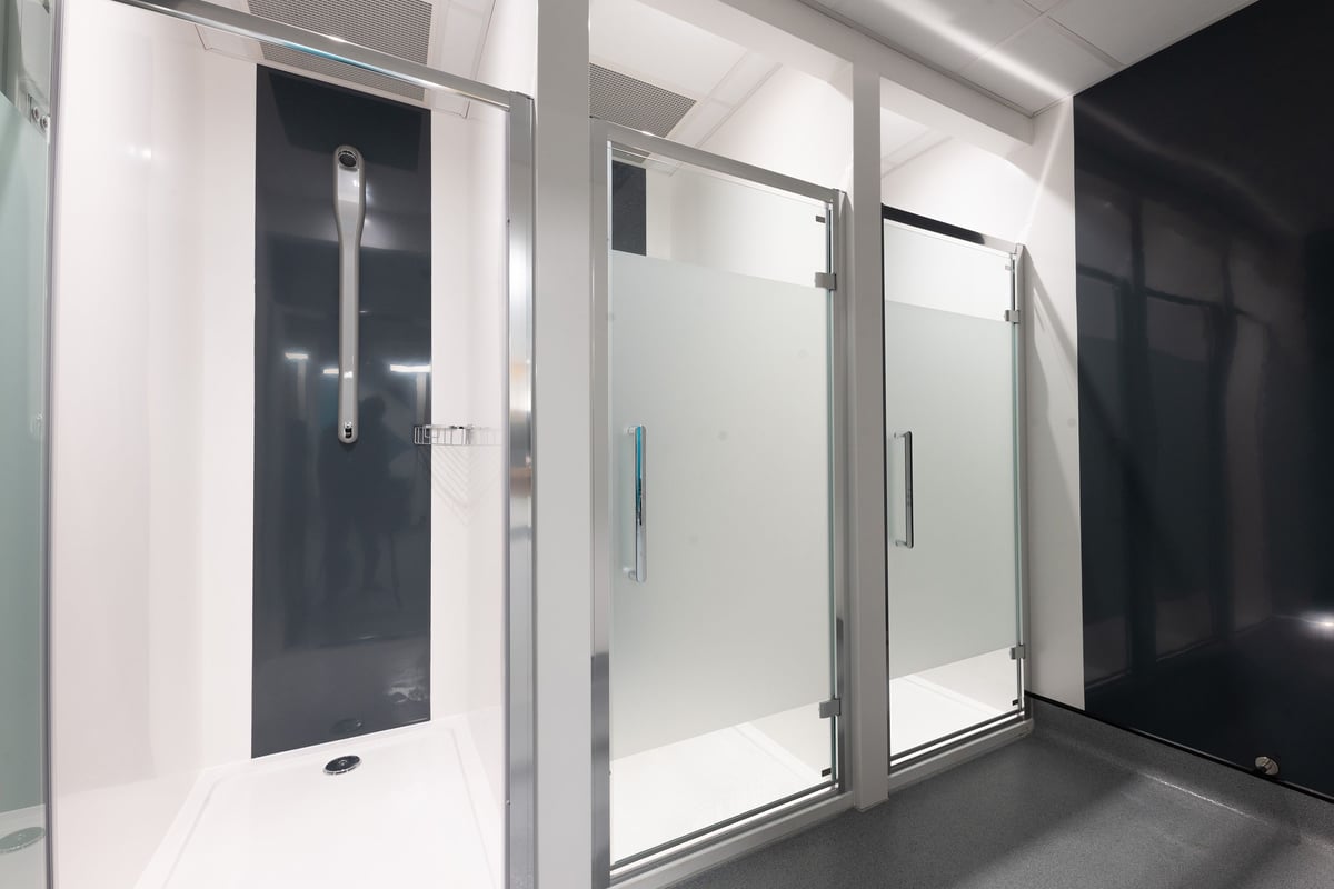 PureGym Southport: Shower cubicles, glass partitions, and tiled flooring - appears to be changing rooms.