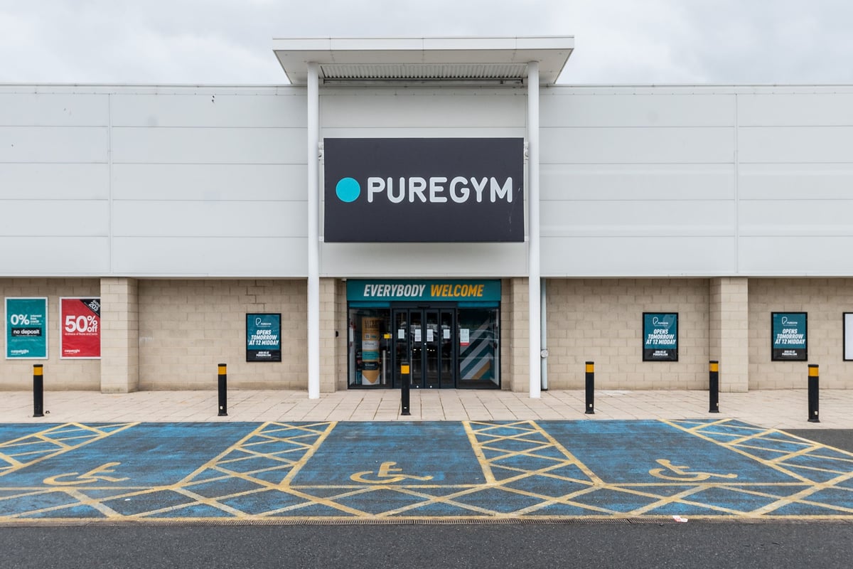 PureGym Blyth: The gym entrance with 'PUREGYM' signage, parking spaces, and promotional banners.
