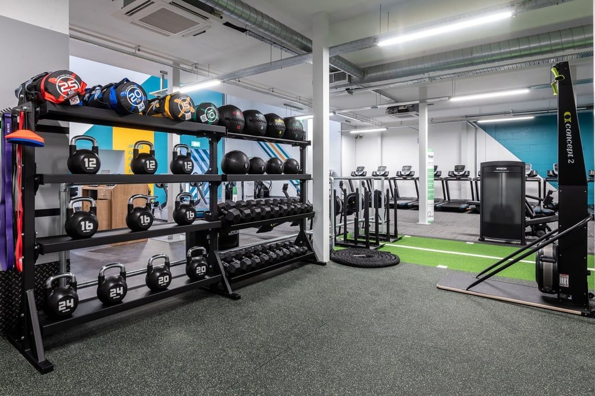 PureGym Inverness Inshes Retail Park: Weight racks, benches, exercise balls, and rubberized gym flooring with turf area.