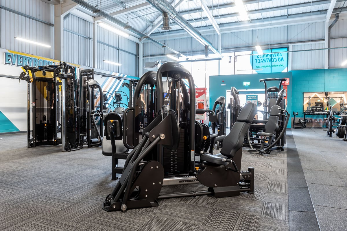 PureGym Spalding: Rows of resistance machines, benches, and cable crossover units in a bright industrial gym space.