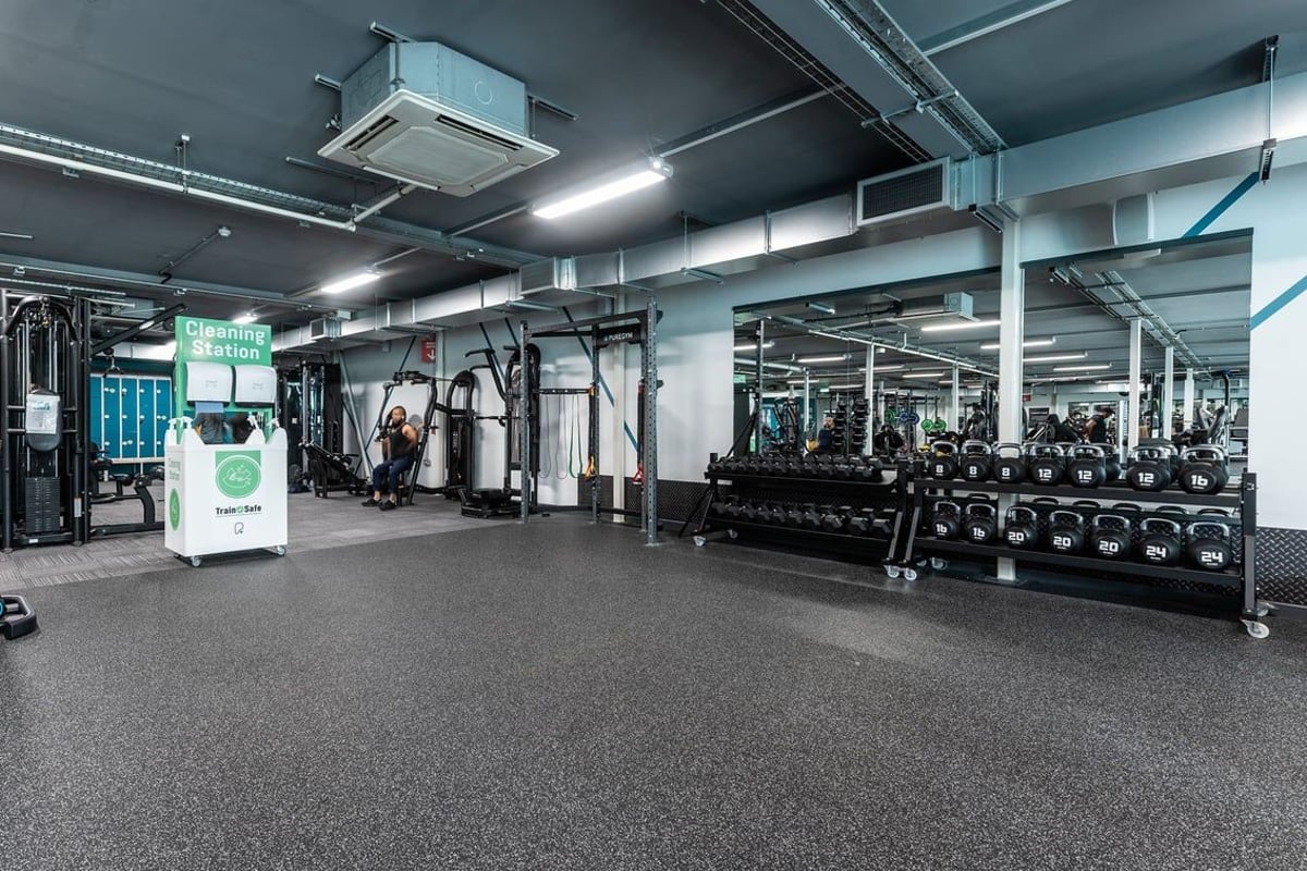 PureGym Oldham: Weight racks, free weights, resistance machines, and rubberized flooring in a modern gym interior.