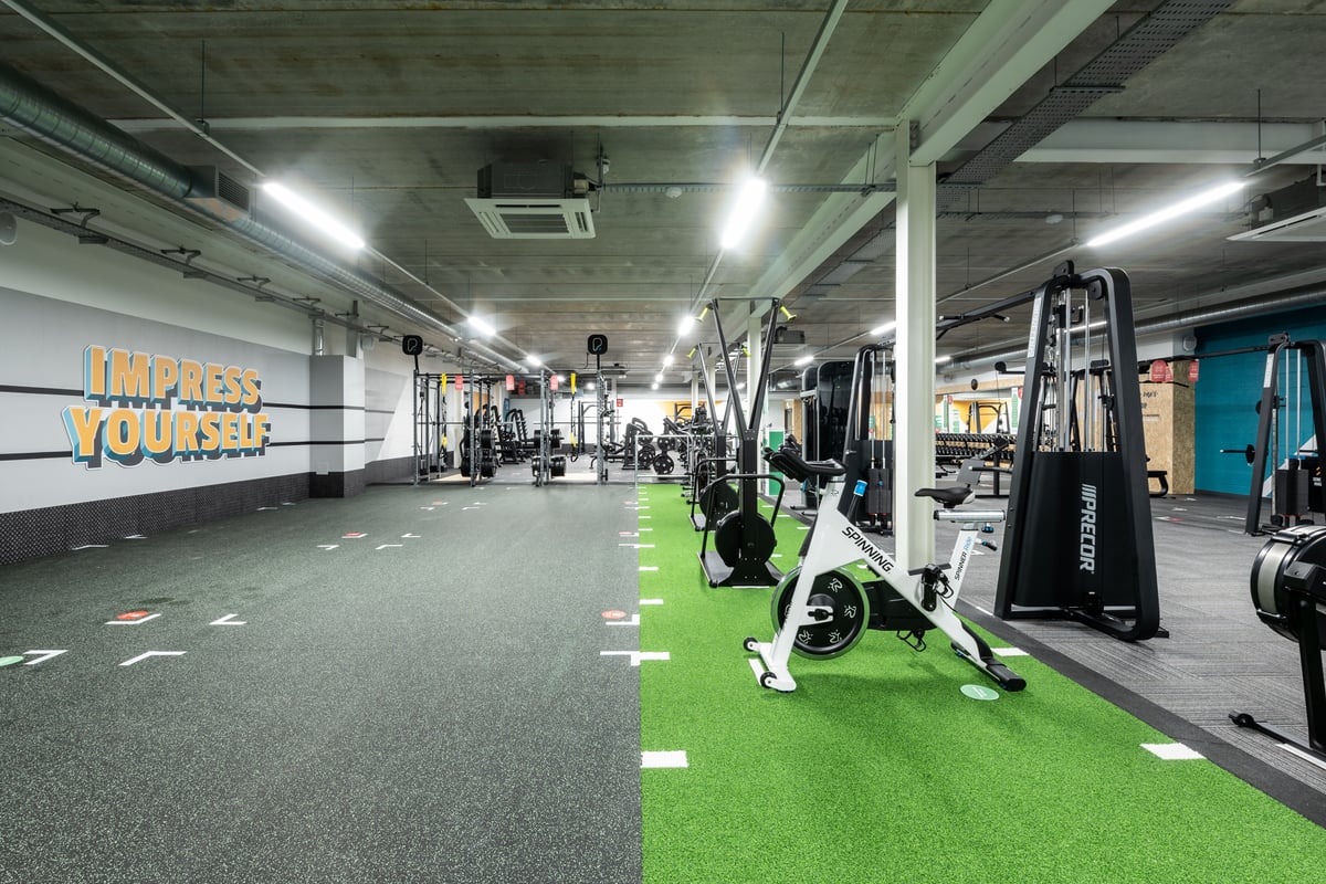 PureGym Plymouth Marsh Mills: Resistance machines, turf area, free weights, and signage on concrete walls of fitness studio.