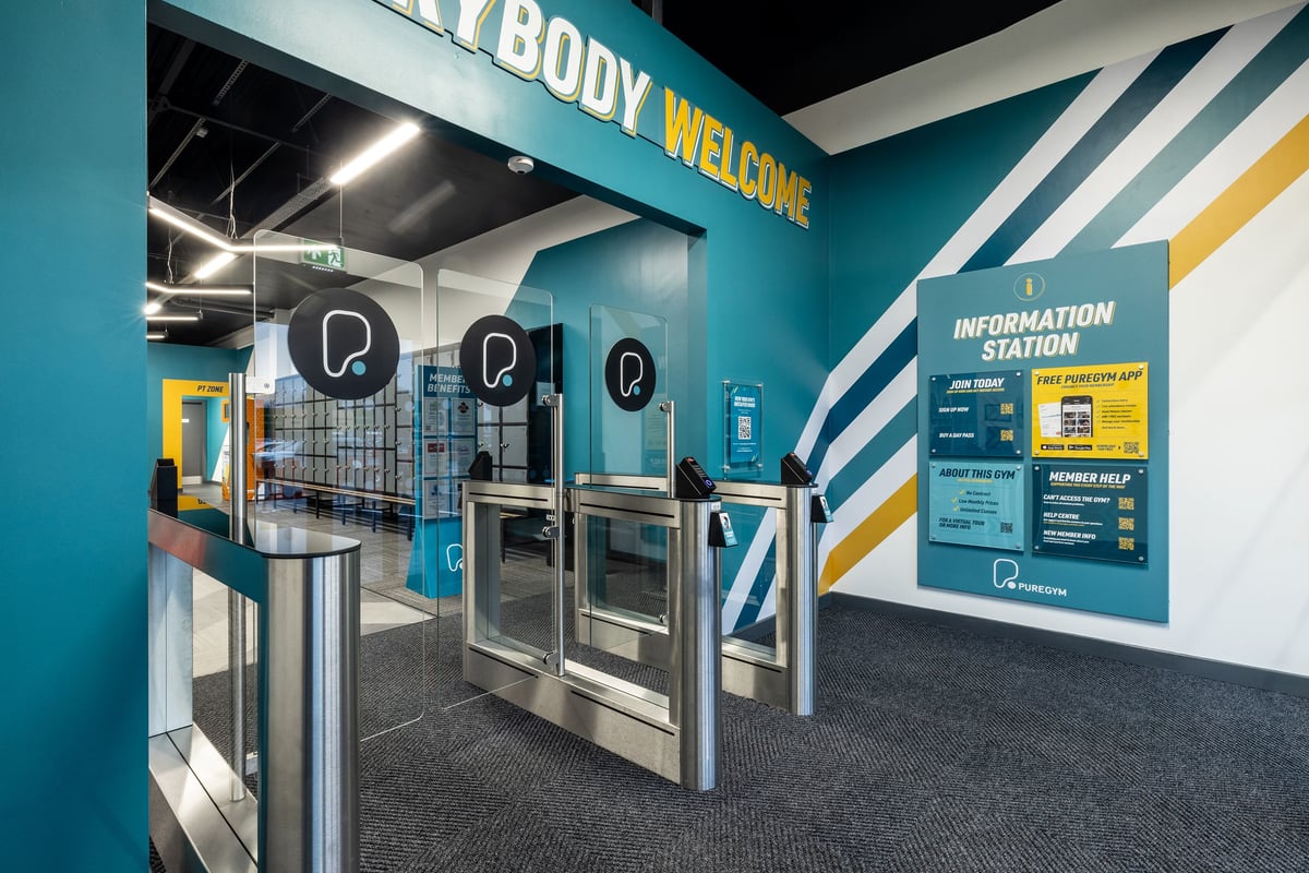 PureGym Washington: Turnstiles, information station, and body welcoming signage in a fitness facility.
