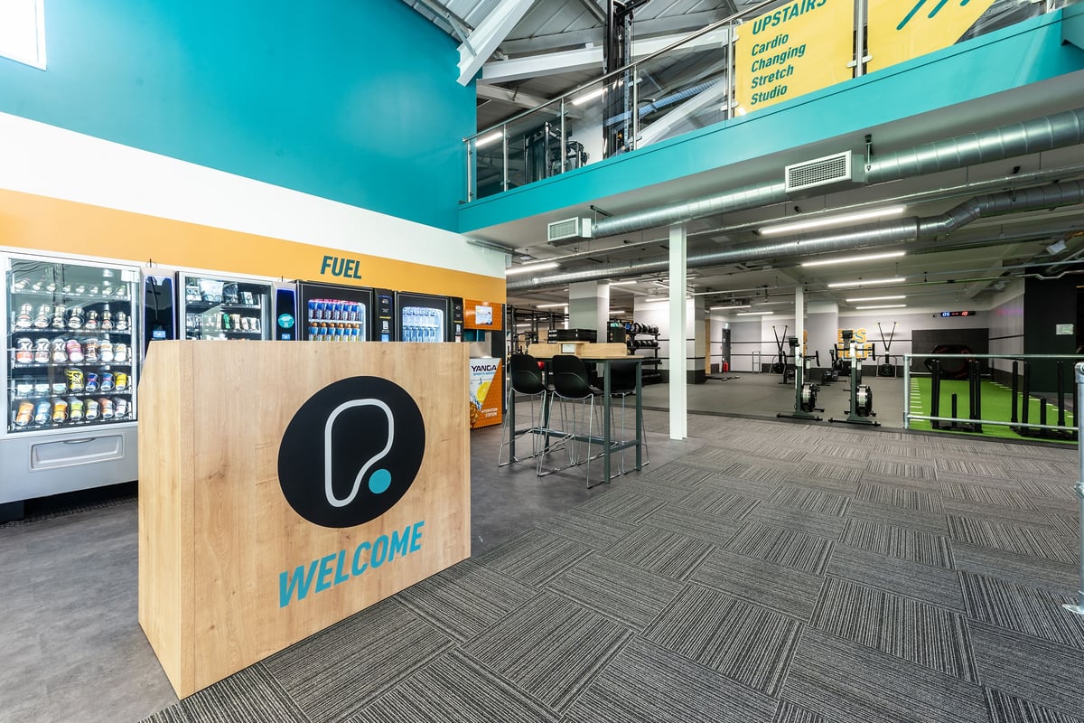 PureGym Bath Victoria Park: Snack vending machine, high stools, waiting area in open space.