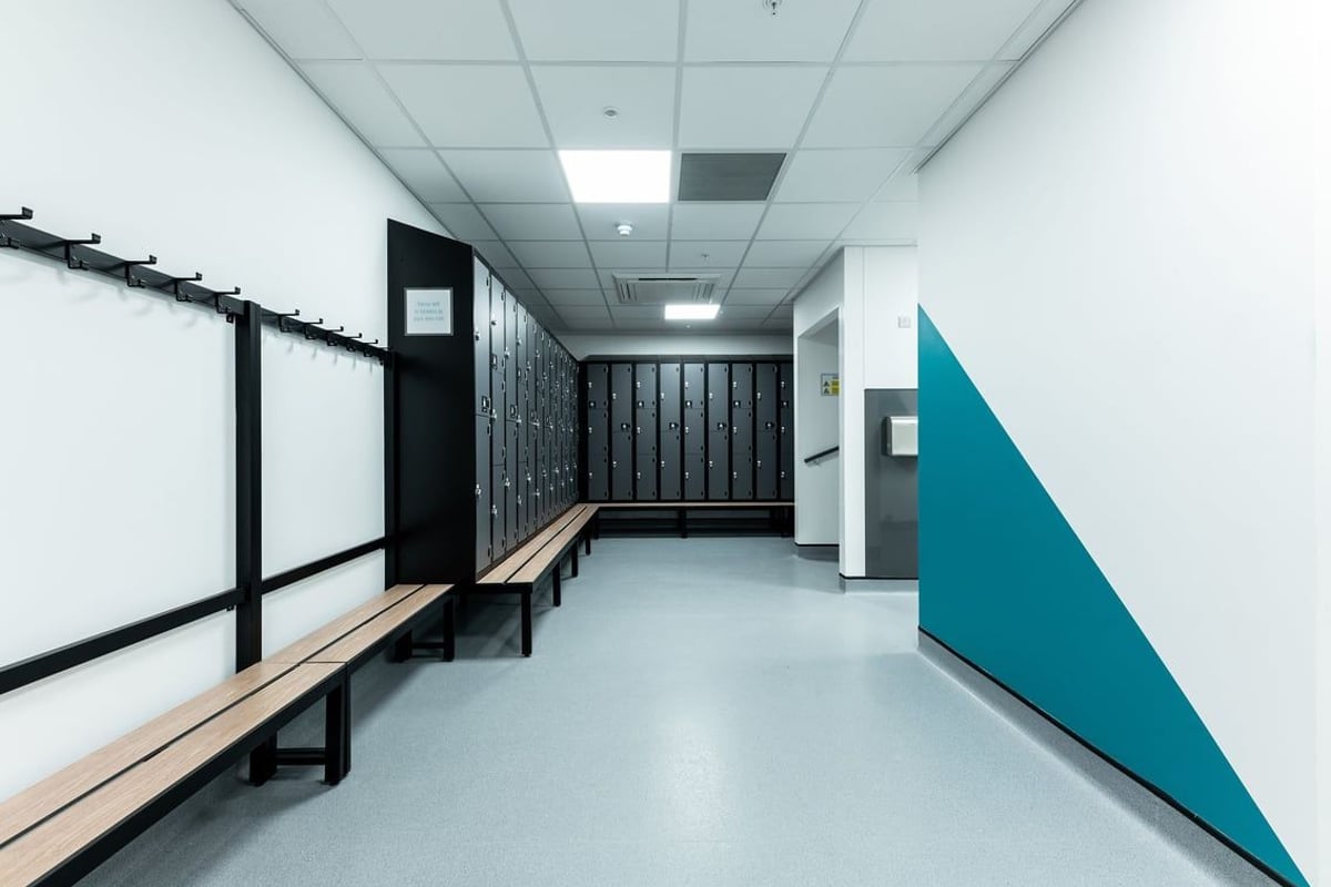 PureGym Rushden: Rows of lockers, benches, and a fitness studio space.