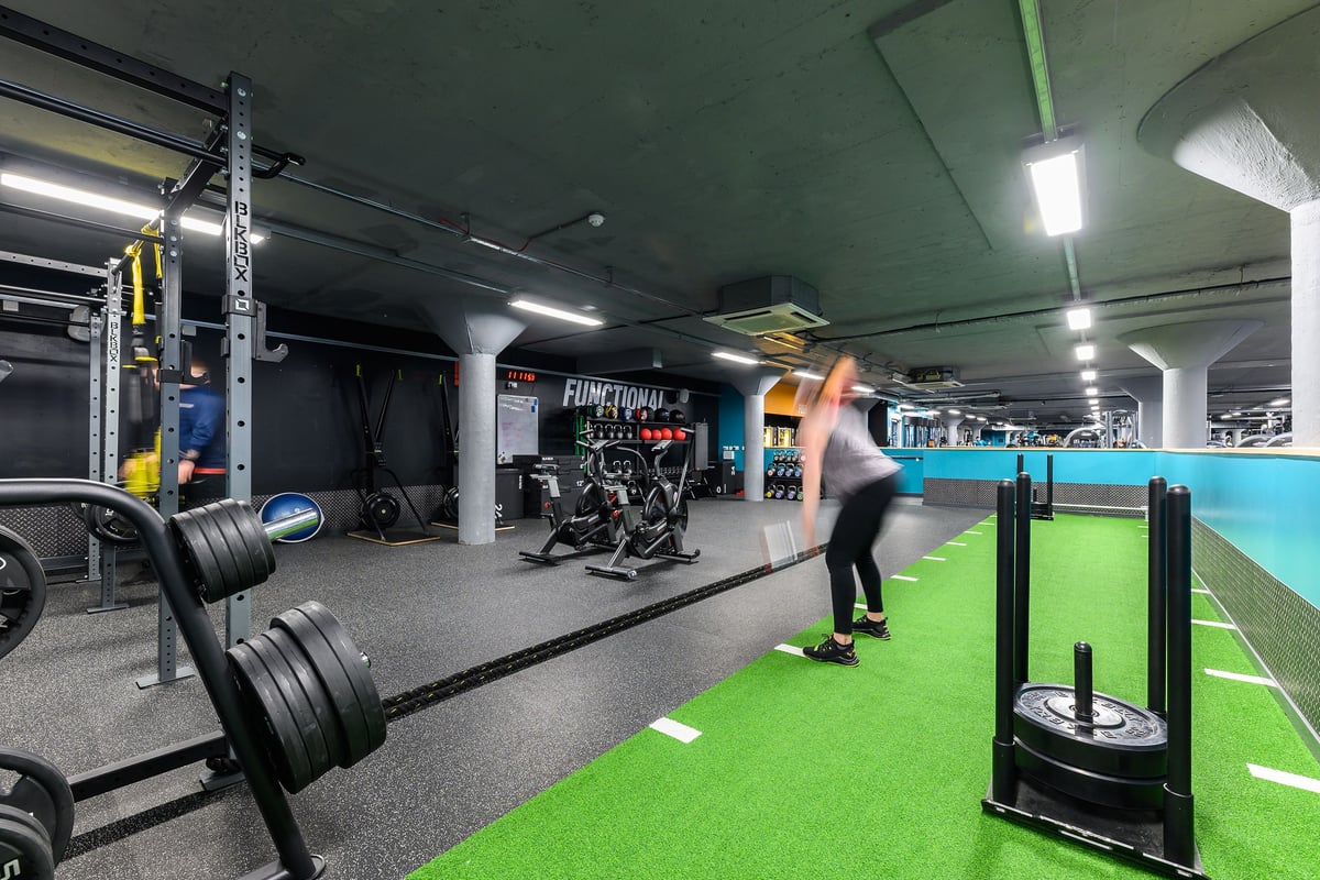 PureGym Nottingham Basford: Weight racks, free weights, turf area for functional training, mirrors along walls.
