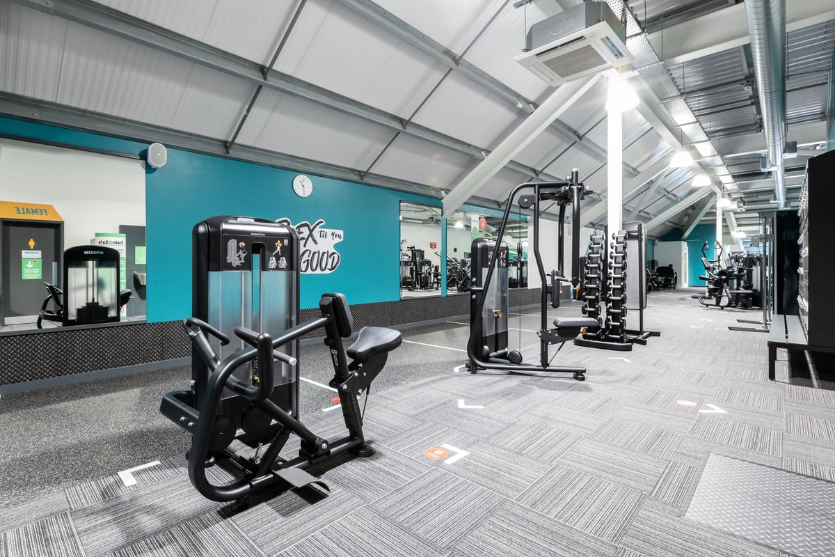 PureGym Plymouth Marsh Mills: Resistance machines, squat racks, free weights, rubberized flooring in a gym setting.