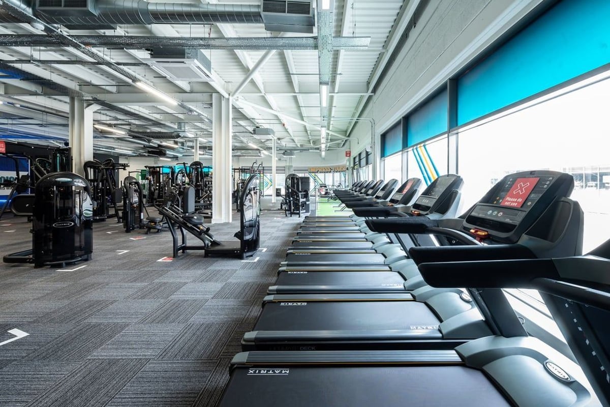 PureGym Aldershot Westgate Retail Park: Rows of treadmills and weight machines in a brightly lit modern gym interior.