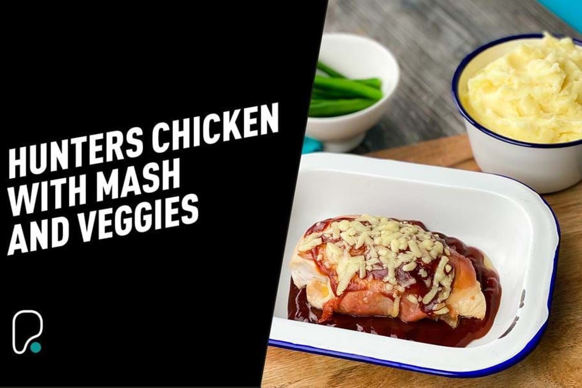 Chicken breast topped with cheese and sauce in a white dish with mash and green beans near