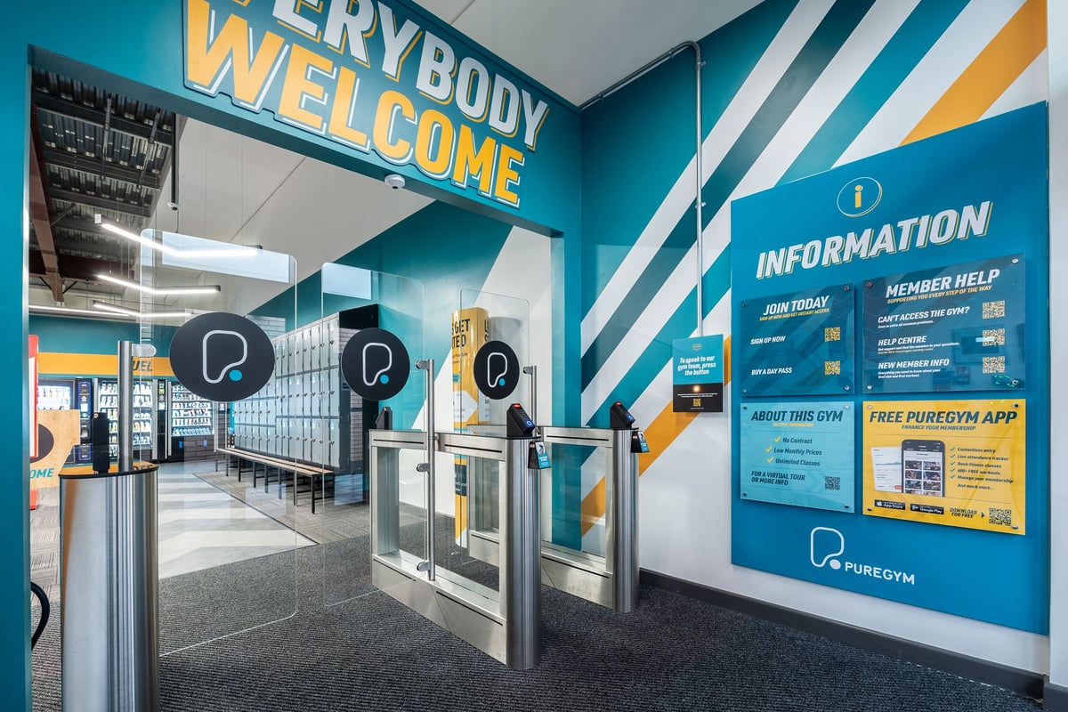 PureGym Craigavon: Entry gates with everybody welcome wall art and informational wall displays.