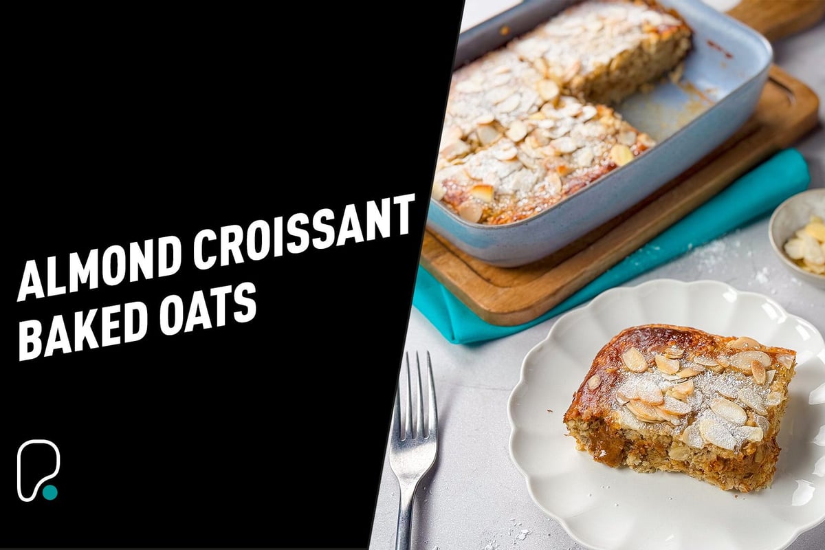 Baked almond croissant oats topped with sliced almonds and powdered sugar on a plate