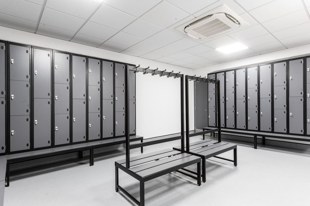 PureGym London Catford Rushey Green: Rows of lockers and benches in the changing room.