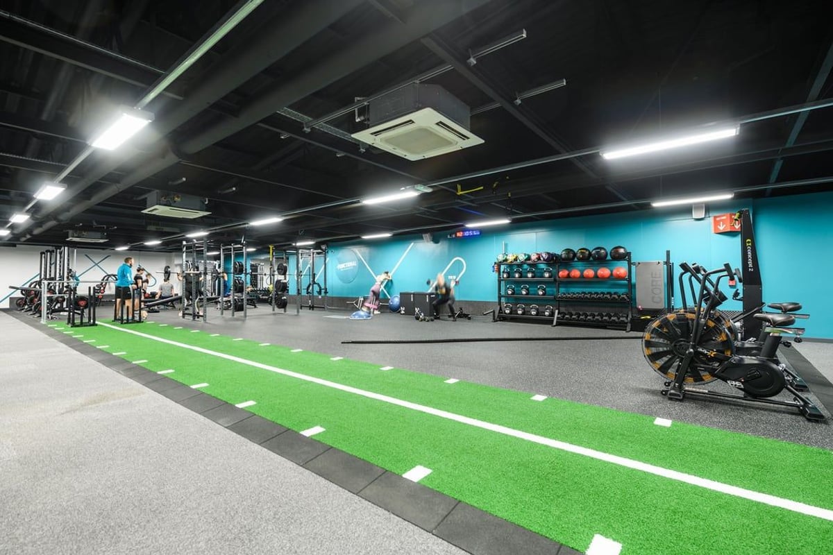 PureGym Portsmouth Commercial Road: Fitness studio with weight racks, dumbbells, kettlebells, turf area, and mirrored wall.