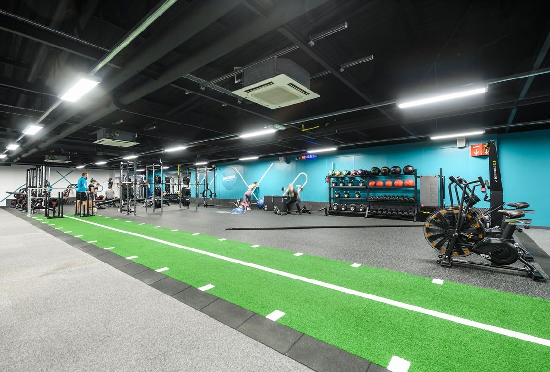 PureGym Portsmouth Commercial Road: Fitness studio with weight racks, dumbbells, kettlebells, turf area, and mirrored wall.