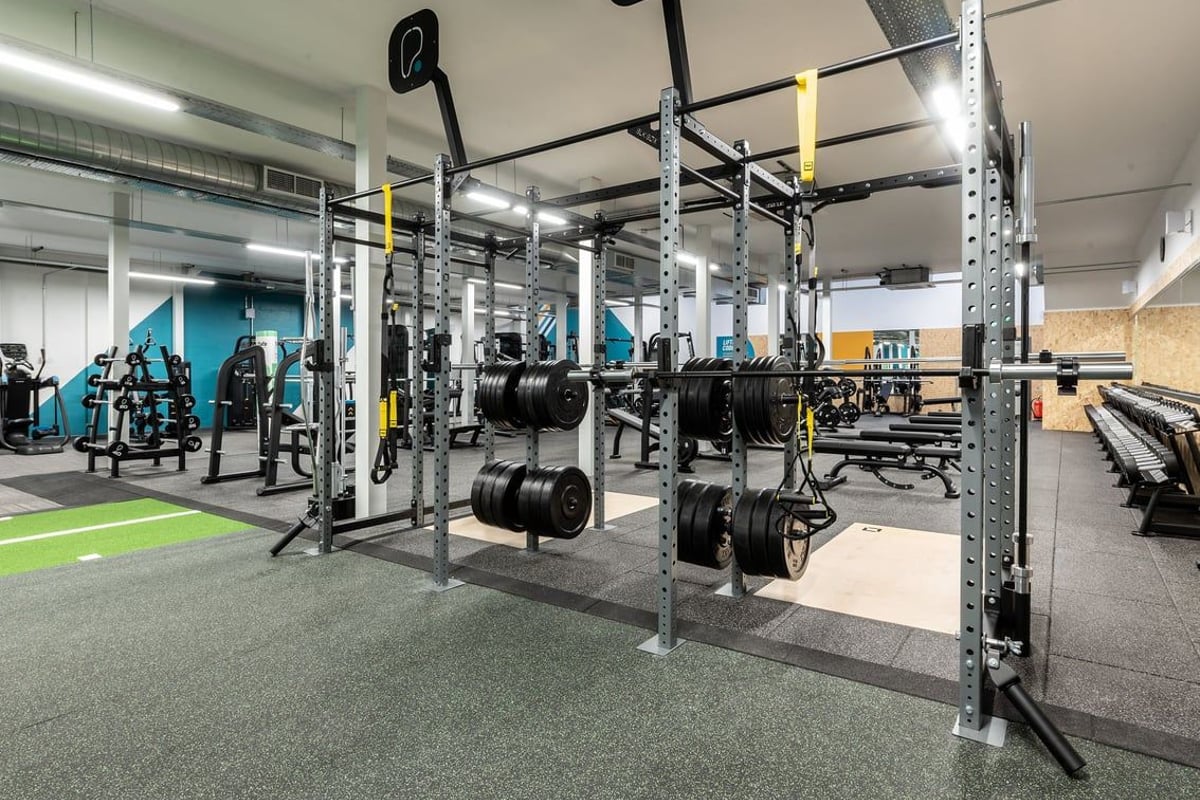 PureGym Inverness Inshes Retail Park: Squat racks, weight plates, free weights, and rubberized flooring in a gym setting.