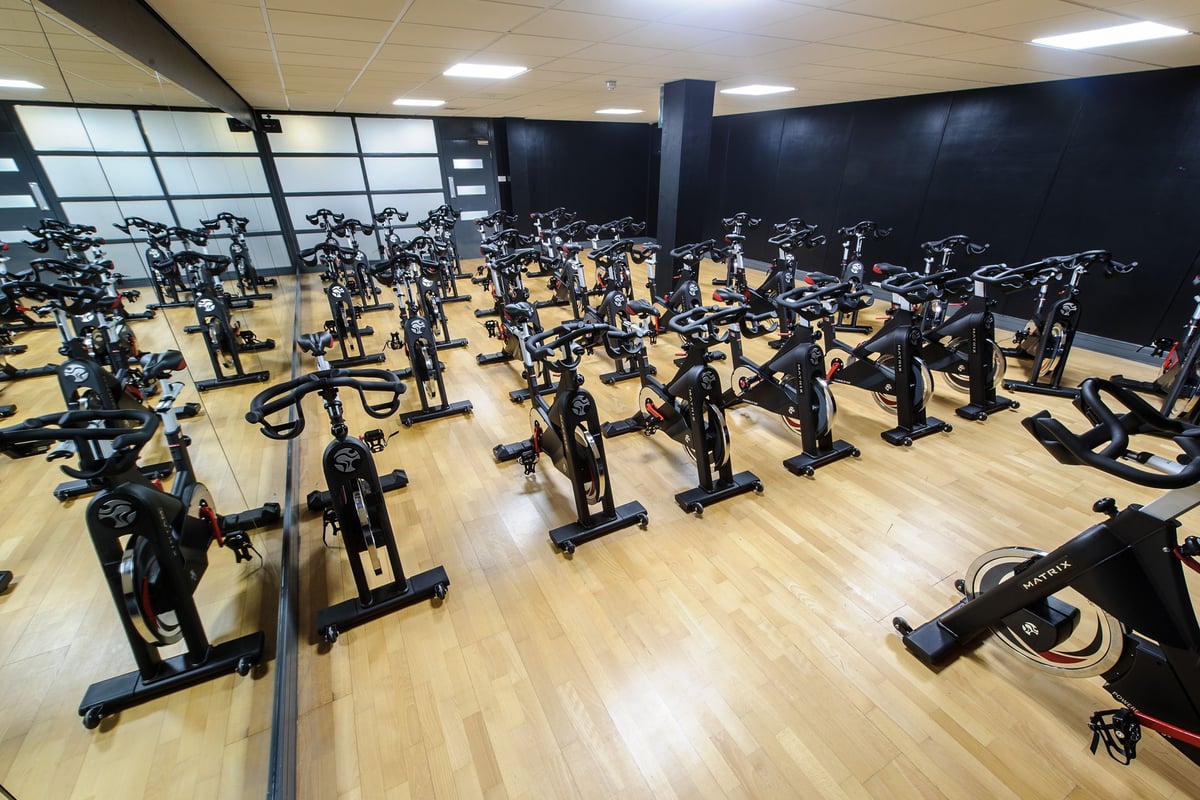 PureGym Bedford Heights: Rows of stationary bikes and spin cycles filling an indoor studio space.