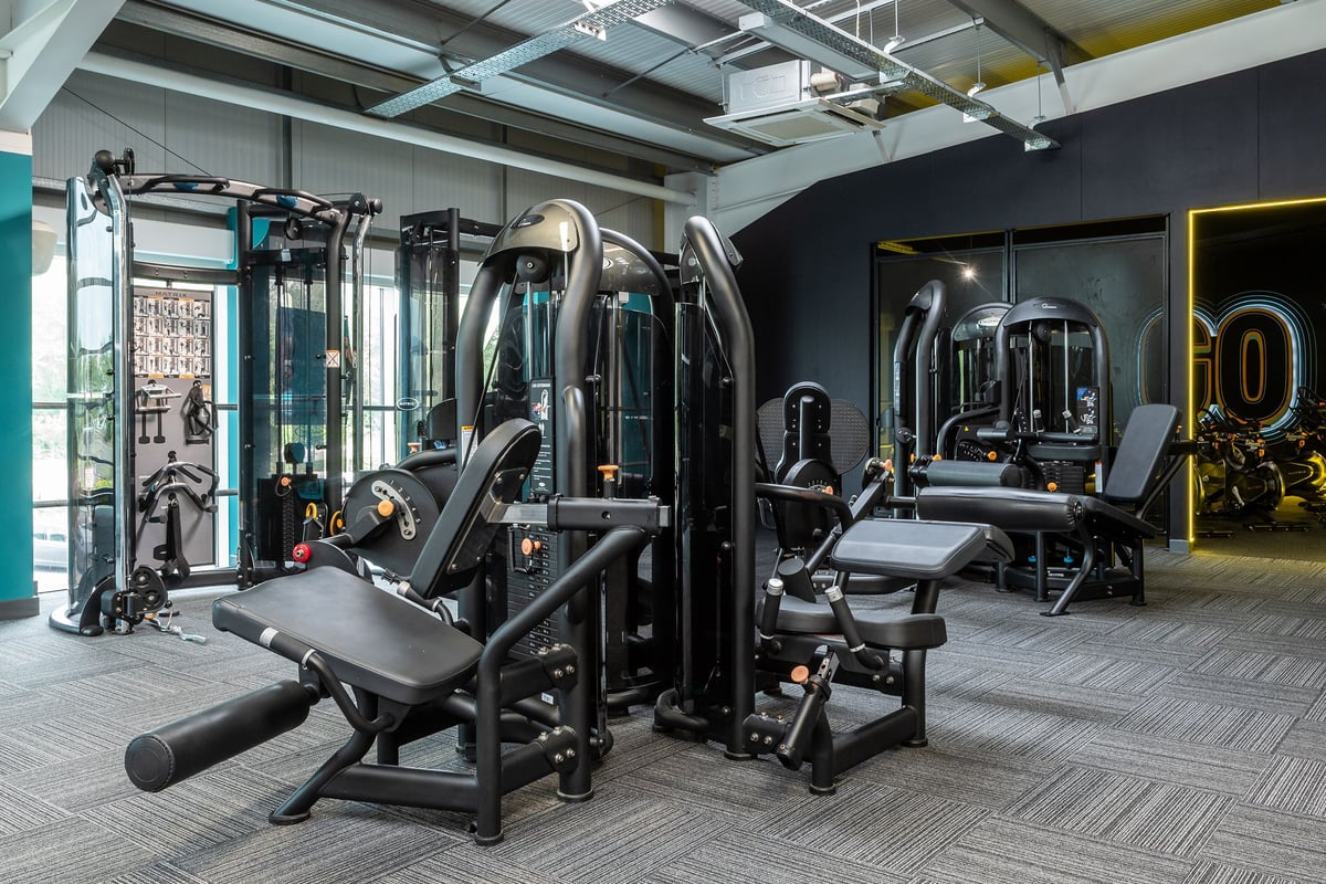 PureGym Wirral Bidston Moss: Resistance machines, cable crossovers, weight benches, and rubberized flooring in a gym studio.