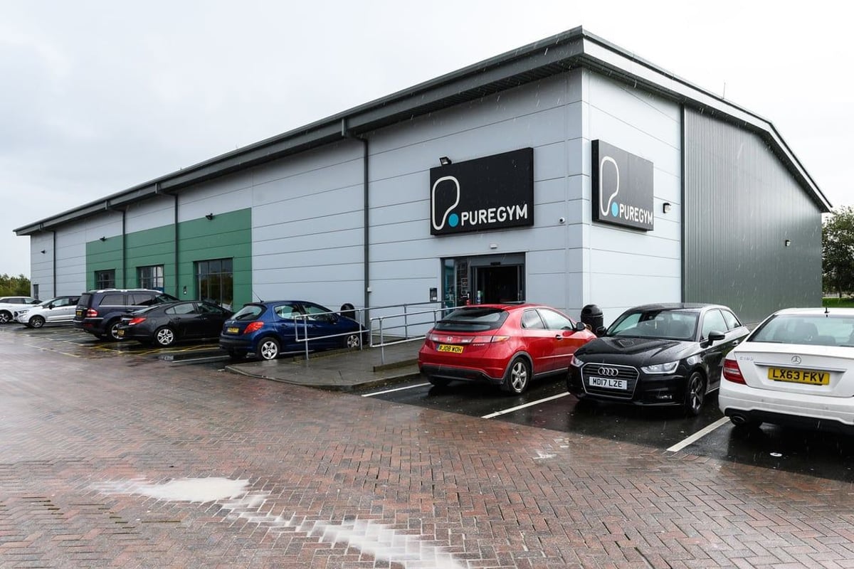 PureGym Widnes: Building exterior with parked cars, 'PureGym' signage visible.