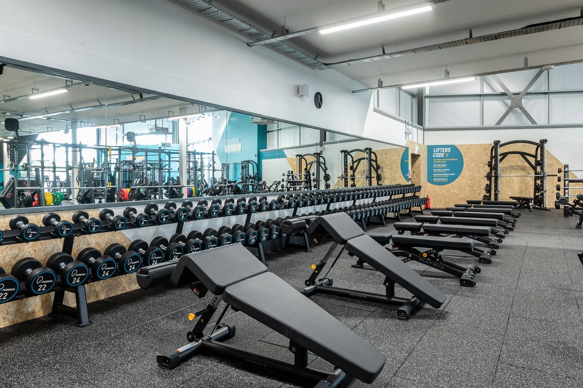 PureGym Nottingham West Bridgford: Rows of dumbbells, weights, benches, and resistance machines in a spacious gym facility.