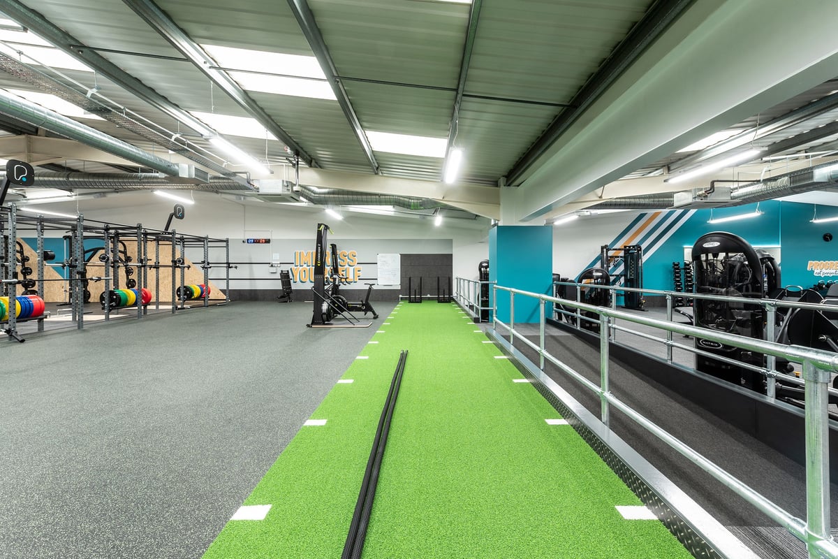 PureGym Cardiff Western Avenue: Functional training area, rig frames, resistance machines, turf track, weight racks.