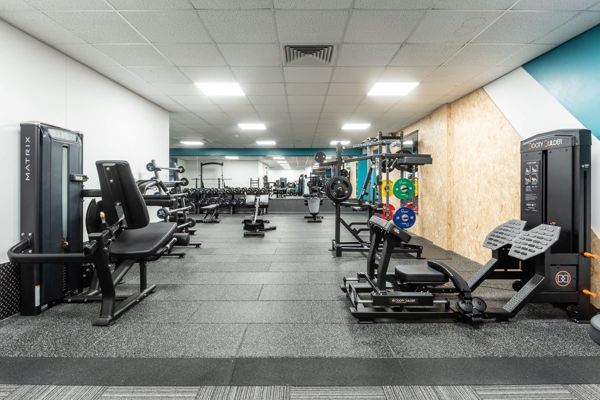 PureGym London Ilford: Gym interior with weight machines, free weights, benches, and rubberized flooring.