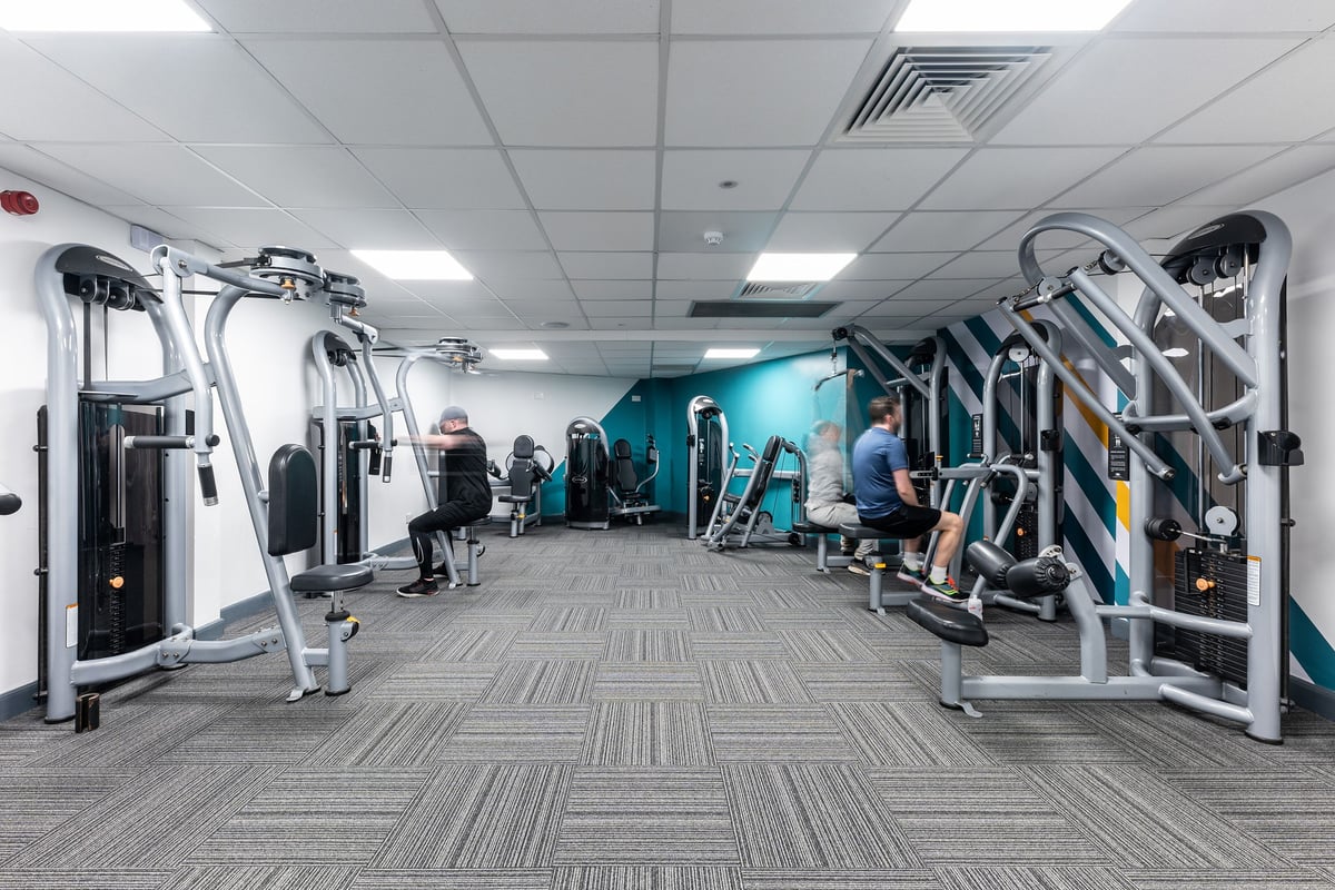 PureGym Bangor Northern Ireland: Rows of resistance machines, free weights, and padded flooring inside a gym studio.