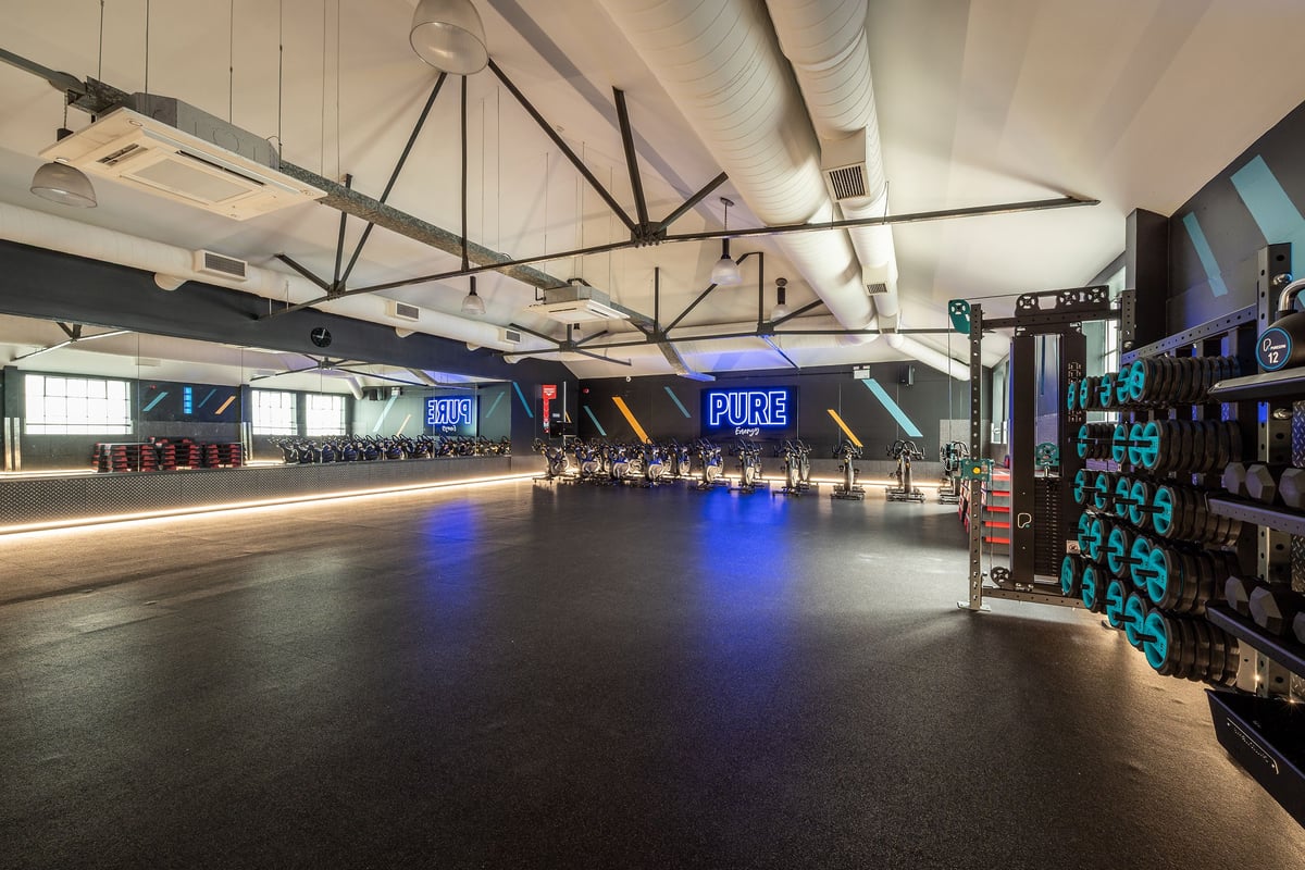 PureGym London Marylebone: Expansive gym interior with branded displays, vaulted ceilings, and neon lighting.