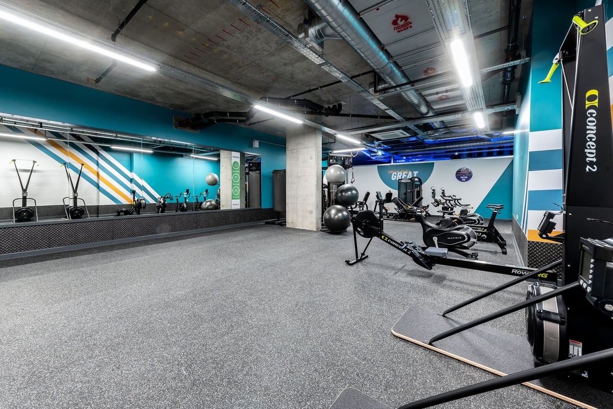 PureGym London Hoxton: Rows of weight sleds, turf track, mirrored walls, strength equipment in a gym studio interior.