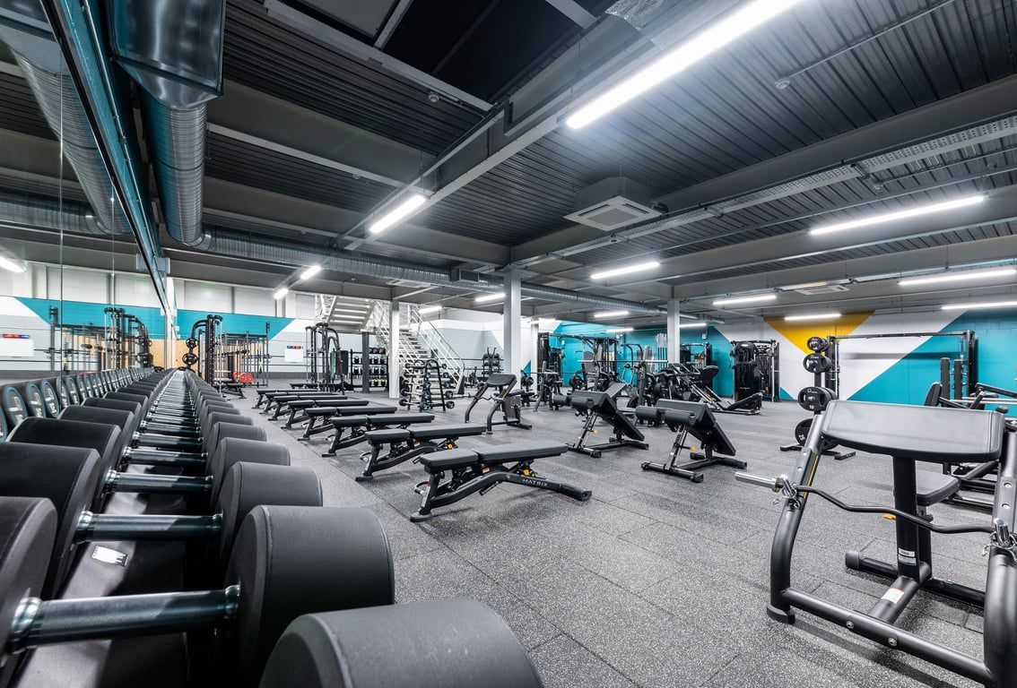 PureGym Sheffield Crystal Peaks: Rows of weight benches, resistance machines, free weights, and floor mats.