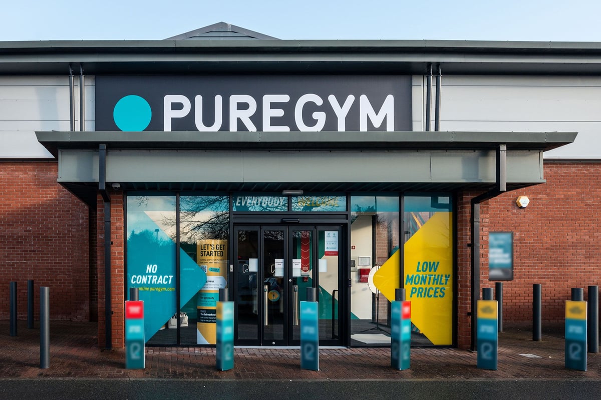 PureGym Oswestry: Exterior of gym with blue branding, featuring "No Contract" and "Low Monthly Prices" signs.