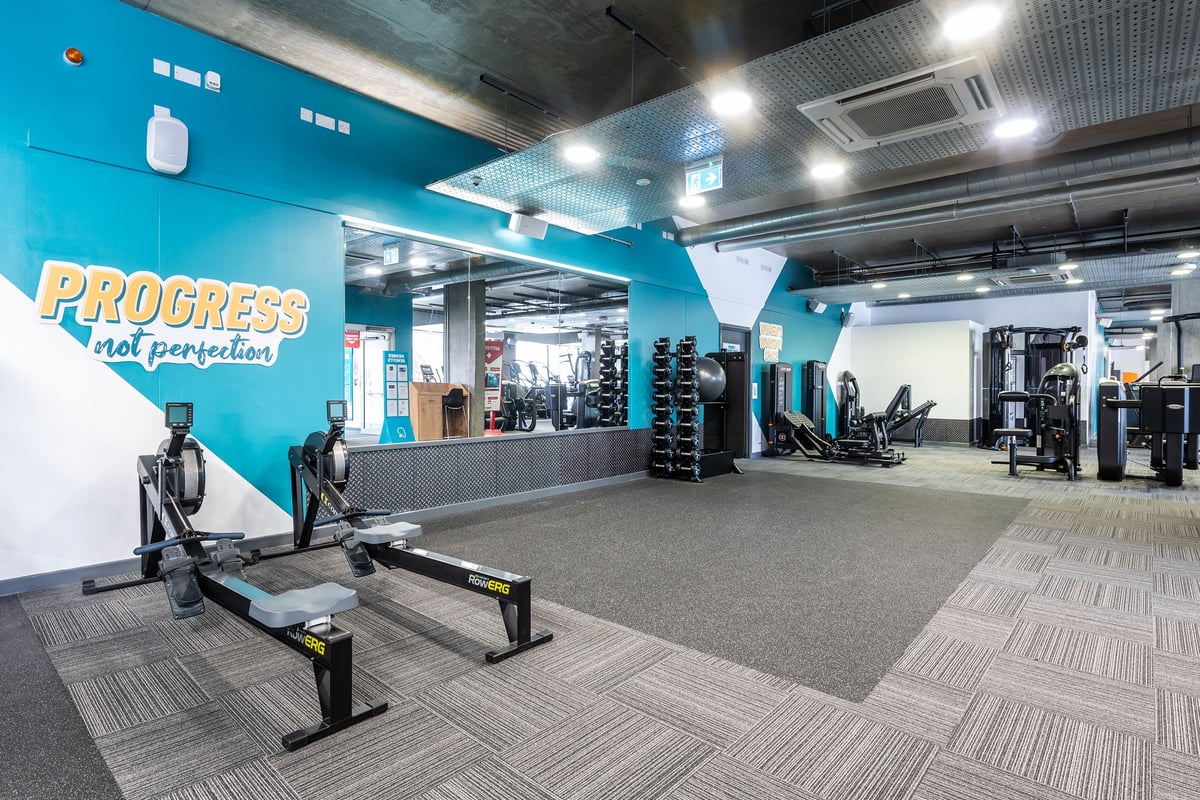PureGym London Limehouse: Weight machines, free weights, benches, rubberized flooring in bright blue-accented gym studio.
