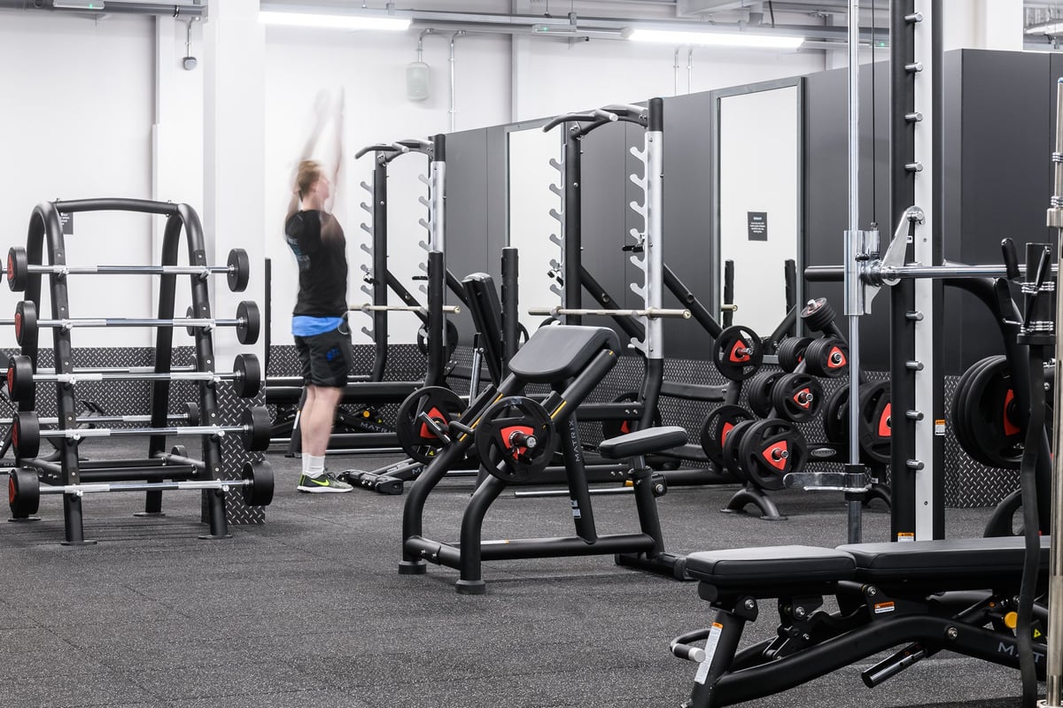 PureGym Aberdeen Wellington Circle: Weight racks, squat cages, benches, dumbbells, and rubberized flooring in a gym setting.